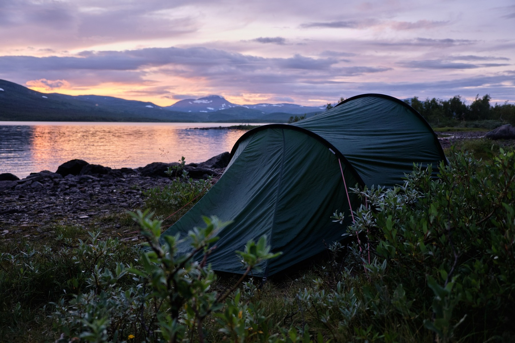 tält placerat på en strand i skymning